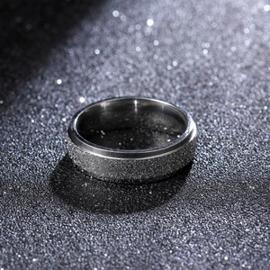 Close-up of 6mm titanium ring featuring a matte frosted texture with polished silver edges