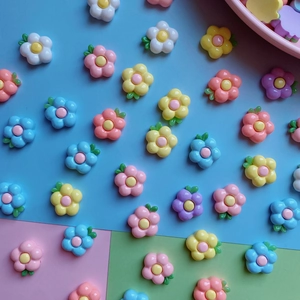 Close-up of colorful resin frangipani flower charms for DIY crafts and accessories