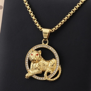 Detailed close-up of golden tiger head pendant with red eyes and sparkling stones