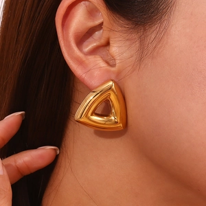 Close-up of minimalist hollow triangle stud earring in 18K gold-plated stainless steel