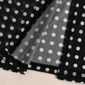 Close-up of the delicate mesh fabric with polka dots and fine edge stitching detail