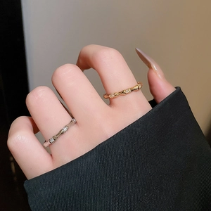 Close-up of gold and silver bamboo style rings with zircon accents on a model's hand