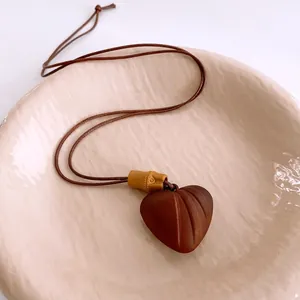 Collier ethnique avec pendentif coeur en bois, perles marron foncé et cordon