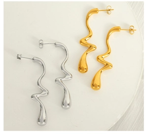 Detailed view of elegant wavy S-shaped metal drop earrings in gold and silver finish