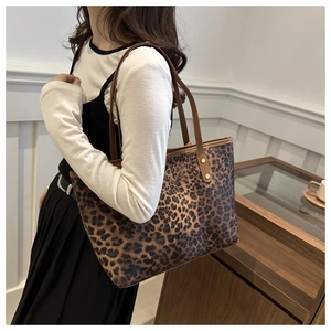 Leopard print tote bag worn on shoulder by model in a minimalist modern interior