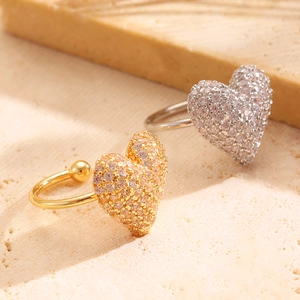 Detailed macro shot of gold and silver heart ear clips with pave-set zircon crystals