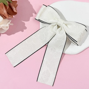 Elegant white fabric bow hair clip with black piping and delicate floral jacquard patterns