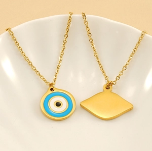 Detail of round and diamond-shaped gold evil eye pendants on a white plate