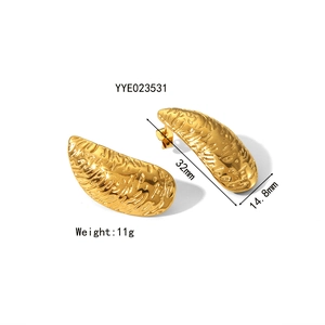 Détail des créoles dorées en acier titane avec texture et dimensions de 32 mm