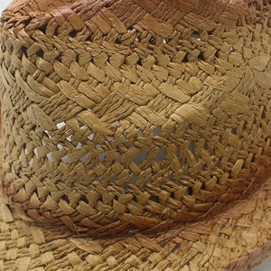 Close-up of cross-woven natural straw fabric showing breathable hollow mesh detail