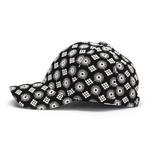 Detalle de gorra de béisbol negra con bordado floral blanco y patrones geométricos