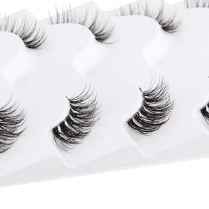 Detailed macro view of natural half-length false eyelashes on a white plastic tray