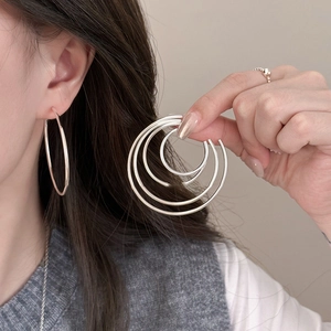 Minimalist silver multi-layer C-shaped hoop earrings for women shown in a lifestyle shot