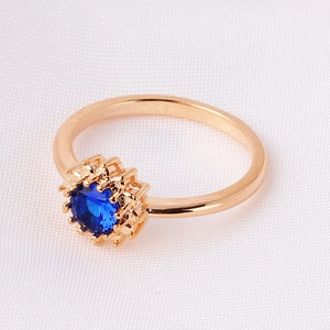 Detailed view of gold plated ring featuring a central blue zircon in a halo setting