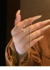 Detail of 18K gold plated flower bracelet with zircon inlays on a dainty bead chain