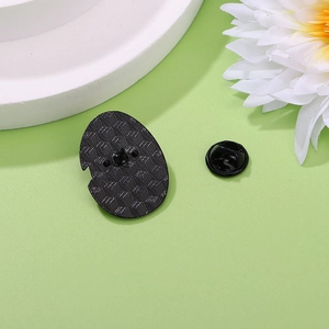 Cute dinosaur enamel pin back view with black rubber clutches and grid texture