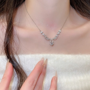 Detailed view of zircon flower pendant necklace on model with elegant V-shaped silver chain