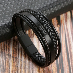 Detail of multi-layer black leather bracelet featuring a matte magnetic buckle and woven texture