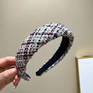Detailed view of wide tweed headband with multicolored woven texture and padded design