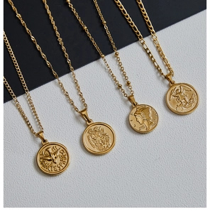 Detail of 18K gold plated titanium necklaces featuring vintage coin and cross pendants