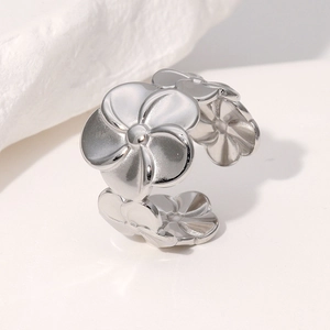Makroaufnahme eines silbernen Blumenrings mit poliertem Metallfinish auf Steinhintergrund