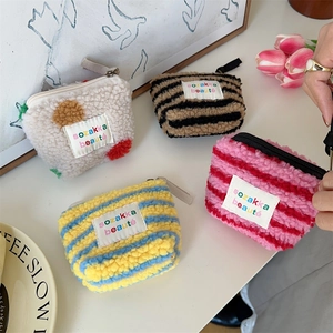 Detailed macro view of plush lambskin mini pouches in various striped and polka dot patterns