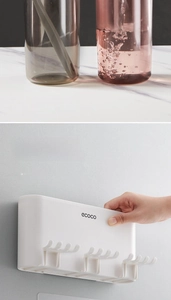 Detail of wall-mounted toothbrush holder with cups and hooks for bathroom storage