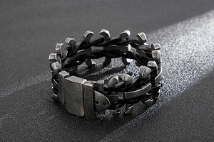 Close-up of industrial men's braided leather bracelet with vintage silver-grey metal