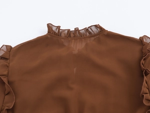 Détails du col à volants et de la texture mousseline sur robe longue marron à manches