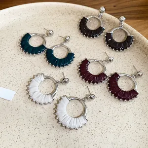 Detailed view of vintage leather wrap earrings in multiple colors on a ceramic tray