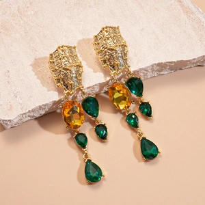 Vintage gold drop earrings with hammered texture and colorful inlaid crystals on stone stand