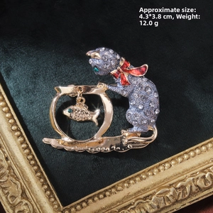 Detailed close-up of a vintage cat and fishbowl brooch with rhinestones and enamel