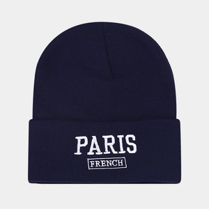 Detailed close-up of navy blue beanie with white PARIS FRENCH letter embroidery
