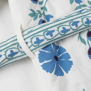 Detail of floral printed cotton jacket showing fine stitching and lace-up strap texture
