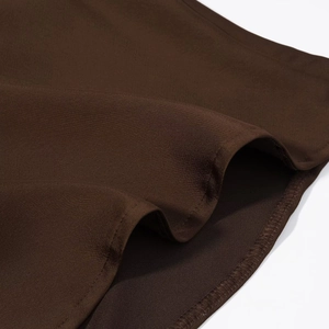Detailed close-up of chocolate brown satin fabric showing fine texture and hem stitching