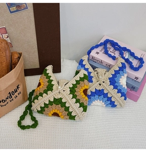 Detail of crochet sunflower tote bag showing granny square patterns and pearl closure