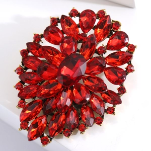 Macro detail of red faceted crystals and gold alloy base on a vintage flower brooch
