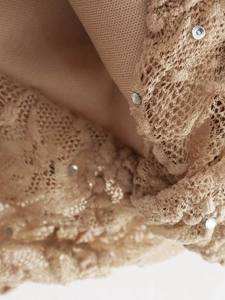 Gros plan sur la dentelle beige avec motifs en résille et strass brillants décoratifs