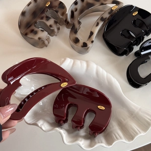 Detail of French luxury heart-shaped hair claw clips in red and leopard patterns