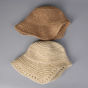 Detailed top view of handmade woven straw sun hats in khaki and cream white with crochet patterns