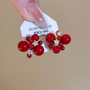 Macro view of 925 silver red zircon earrings with gold plating and pearl cluster