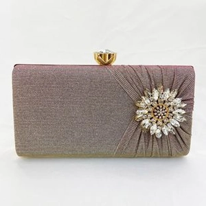 Close-up of sparkling rhinestone flower and pleated gradient fabric on this evening clutch