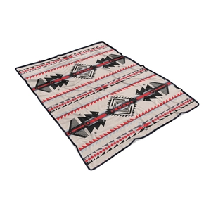 Detail view of ethnic geometric flannel blanket with tribal diamond patterns and hemmed edges