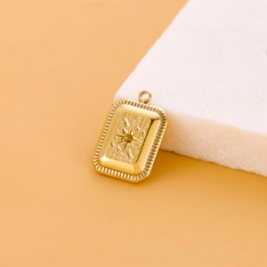 Détail d'un pendentif rectangulaire doré avec relief solaire sur support en pierre