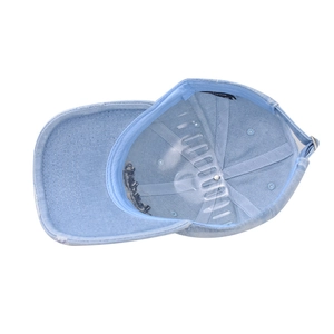 Internal view of a washed denim baseball cap with a 100% cotton label and adjustable strap