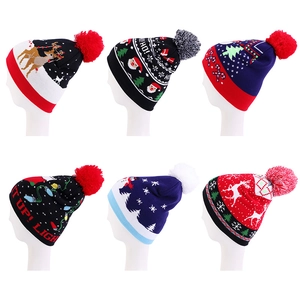 Close-up of six different festive Christmas knitted beanies with colorful plush pom-poms
