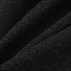 Close-up of black wool fabric texture showing high-density grain and soft drape