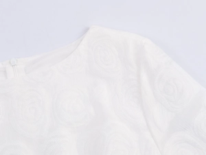 Detailed close-up of the elegant rose floral jacquard texture and white fabric surface
