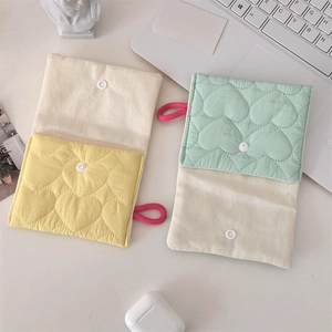 Detailed macro view of heart-quilted cotton pouches with snap button and carry strap