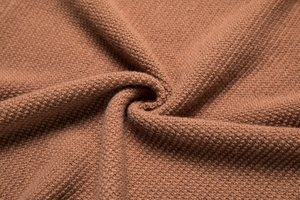 Macro view showing the brown knitted fabric texture and fine weaving craftsmanship of the sweater